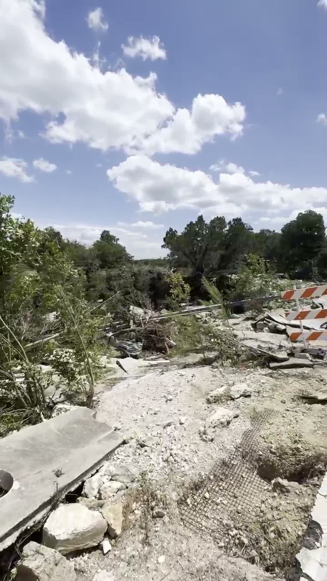 Road and creek bank torn up by the 2025 flood in Leander