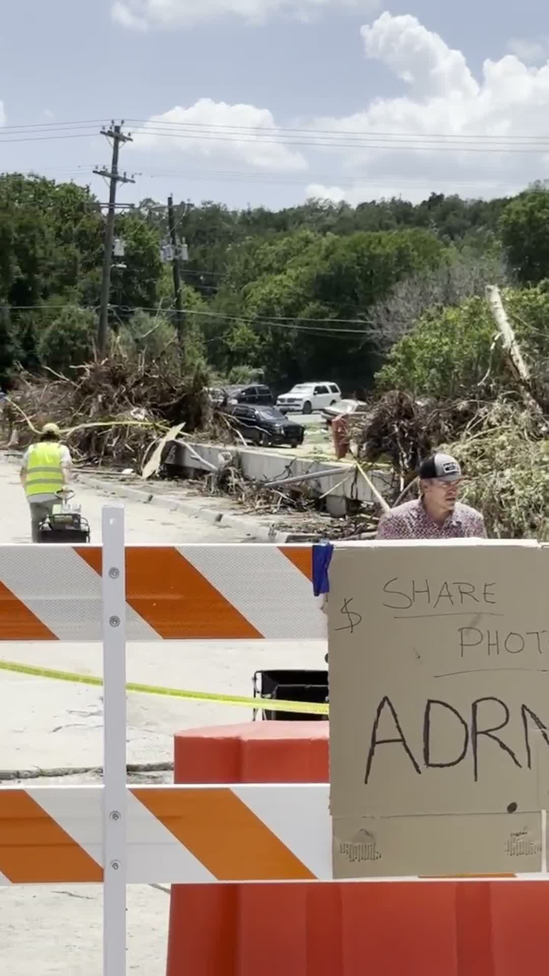 Flood debris and a hand-lettered ADRN.org donation sign